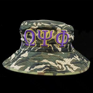 "Green camouflage bucket hat with Omega Psi Phi Greek letters and founding year 1911."